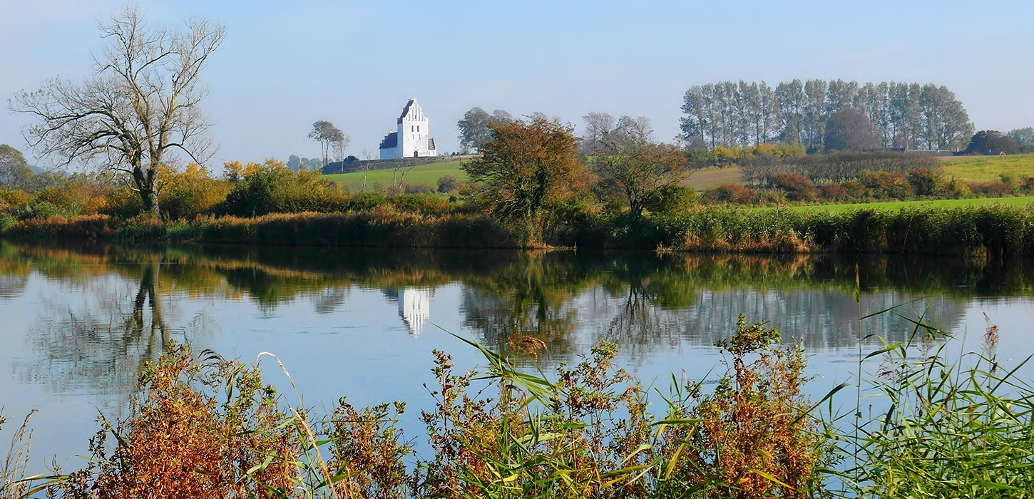 Føns Kirke spejler sig i Fønsvang Sø