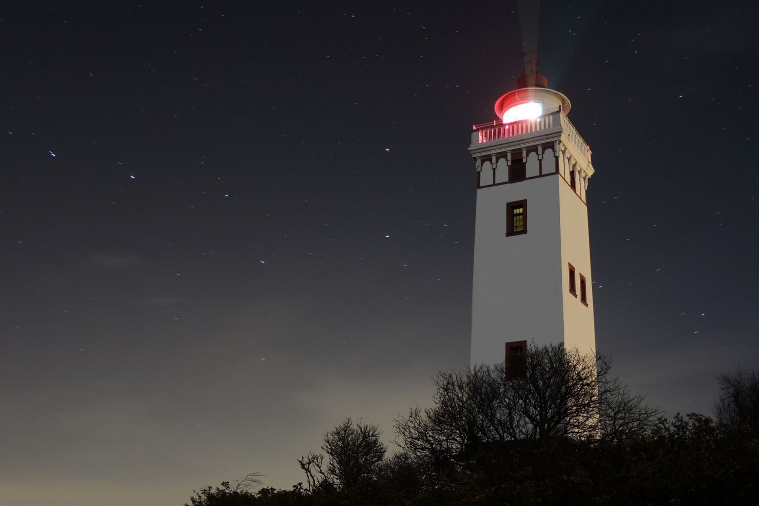 Strib Fyr set om aftenen med stjerne på himlen og lys i fyret